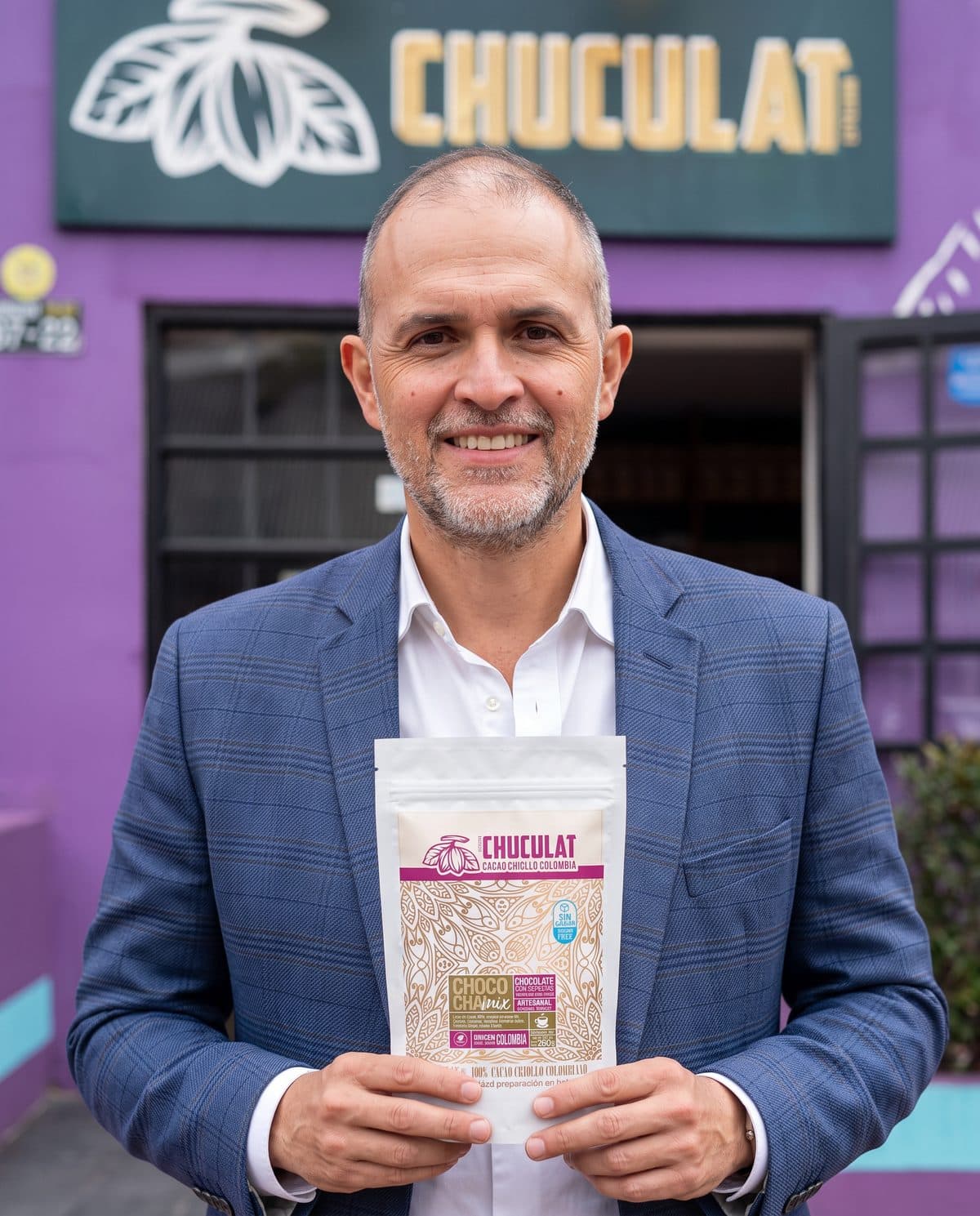 Hernán, fundador de CHUCULAT, frente a la tienda con un producto